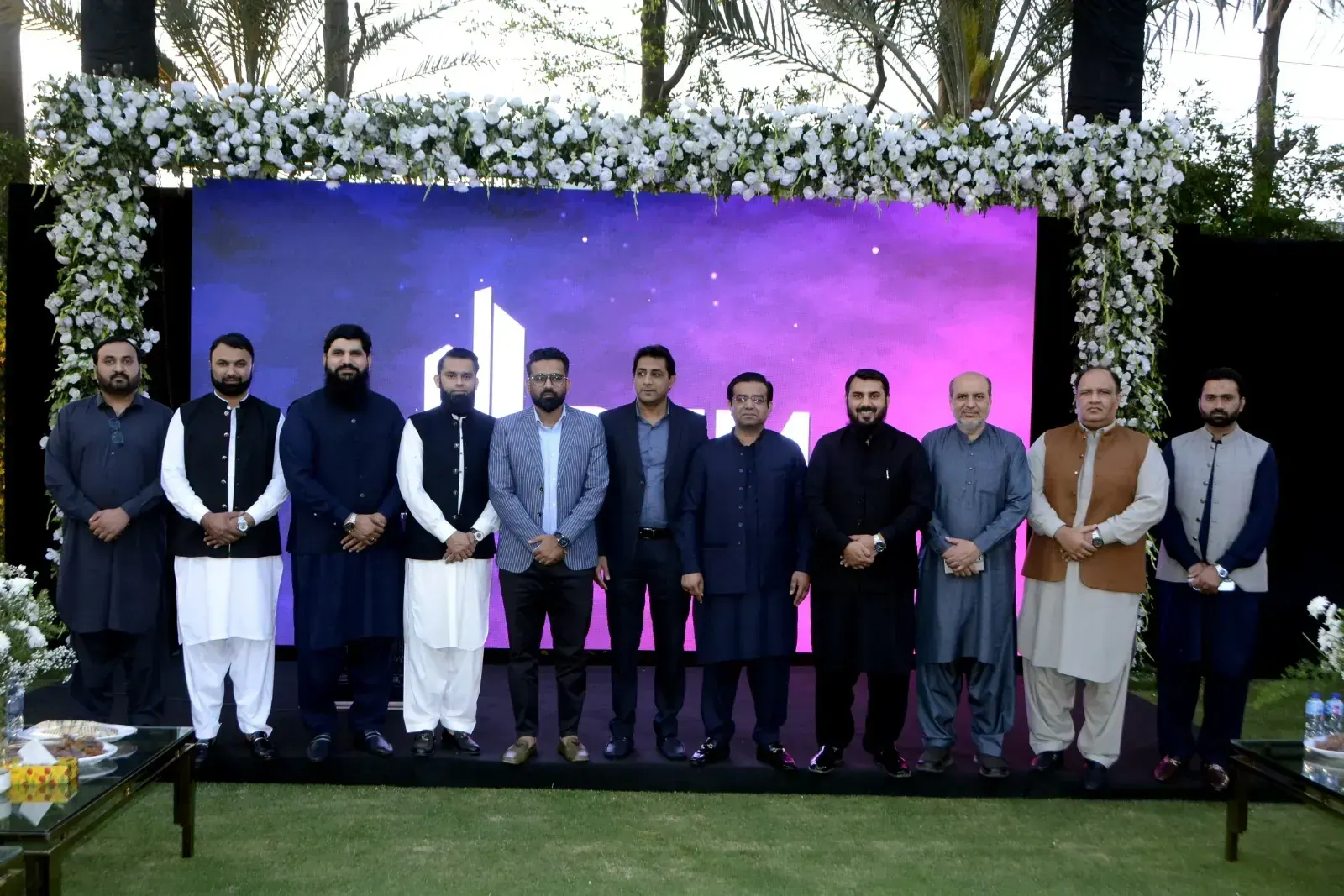 Team gathered under a floral arch at a partner event.