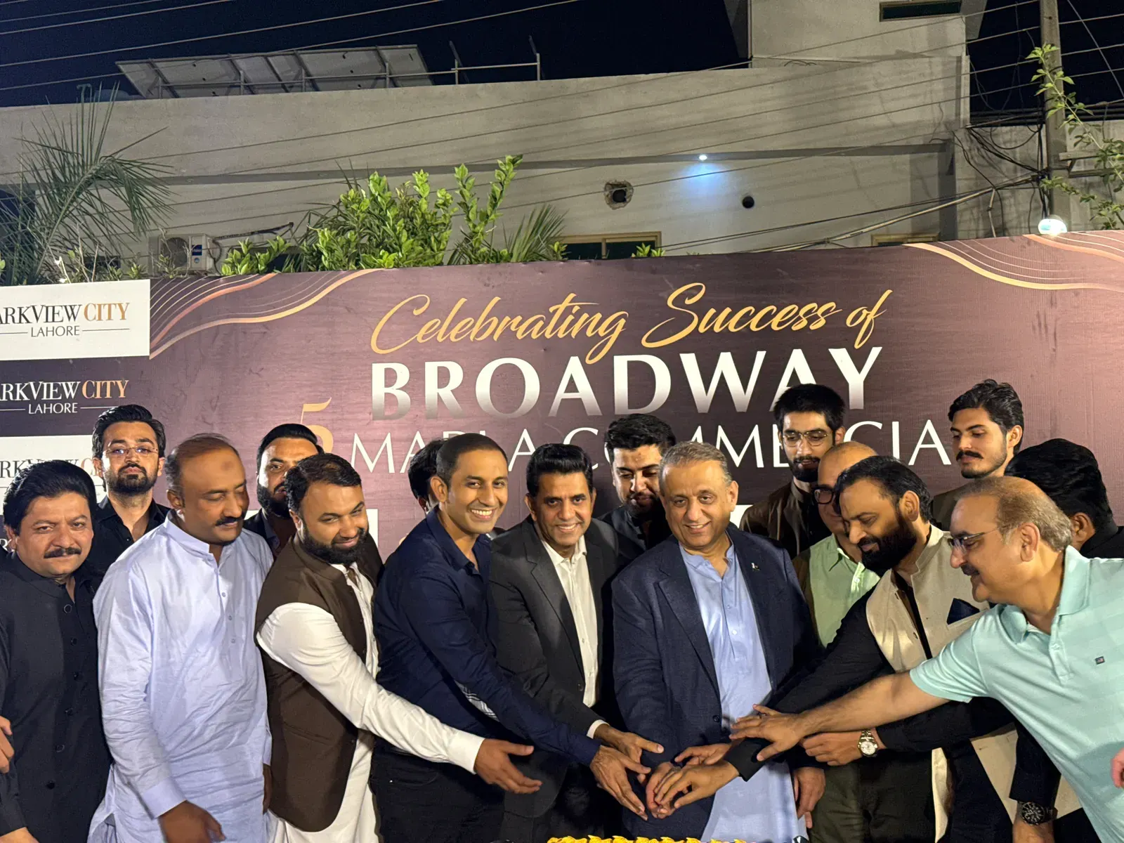 Hands joined over a launch celebration cake at a Parkview City unveiling.